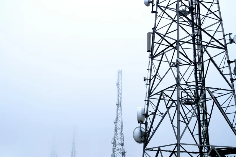 A lattice tower carrying cellular antennas, seen from below