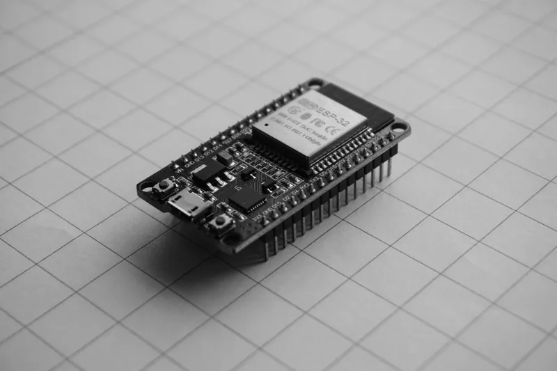 Black microcontroller development board with metal pins
