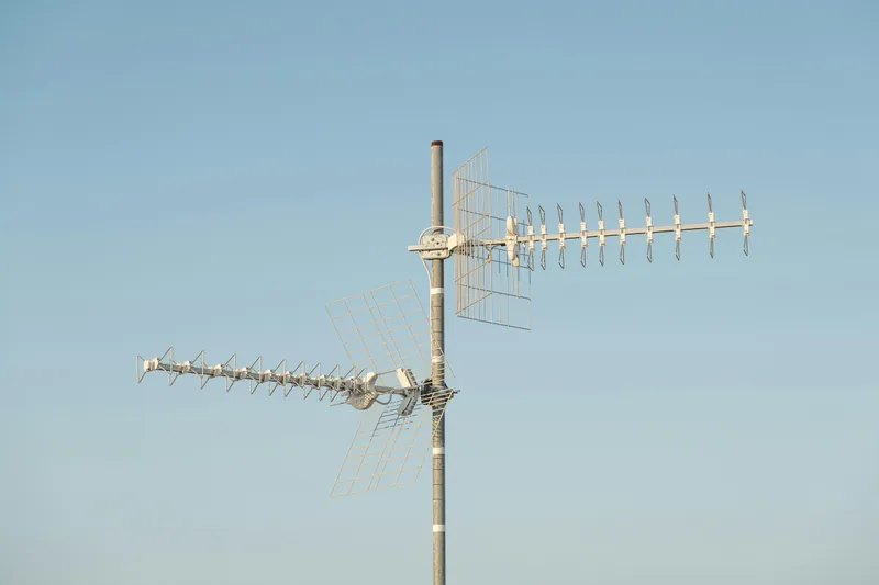 Rooftop antennas against a clear blue sky