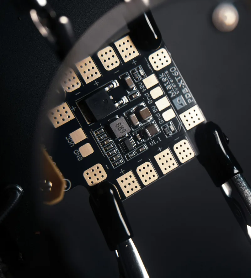 Electronic board held by clamps against a dark background