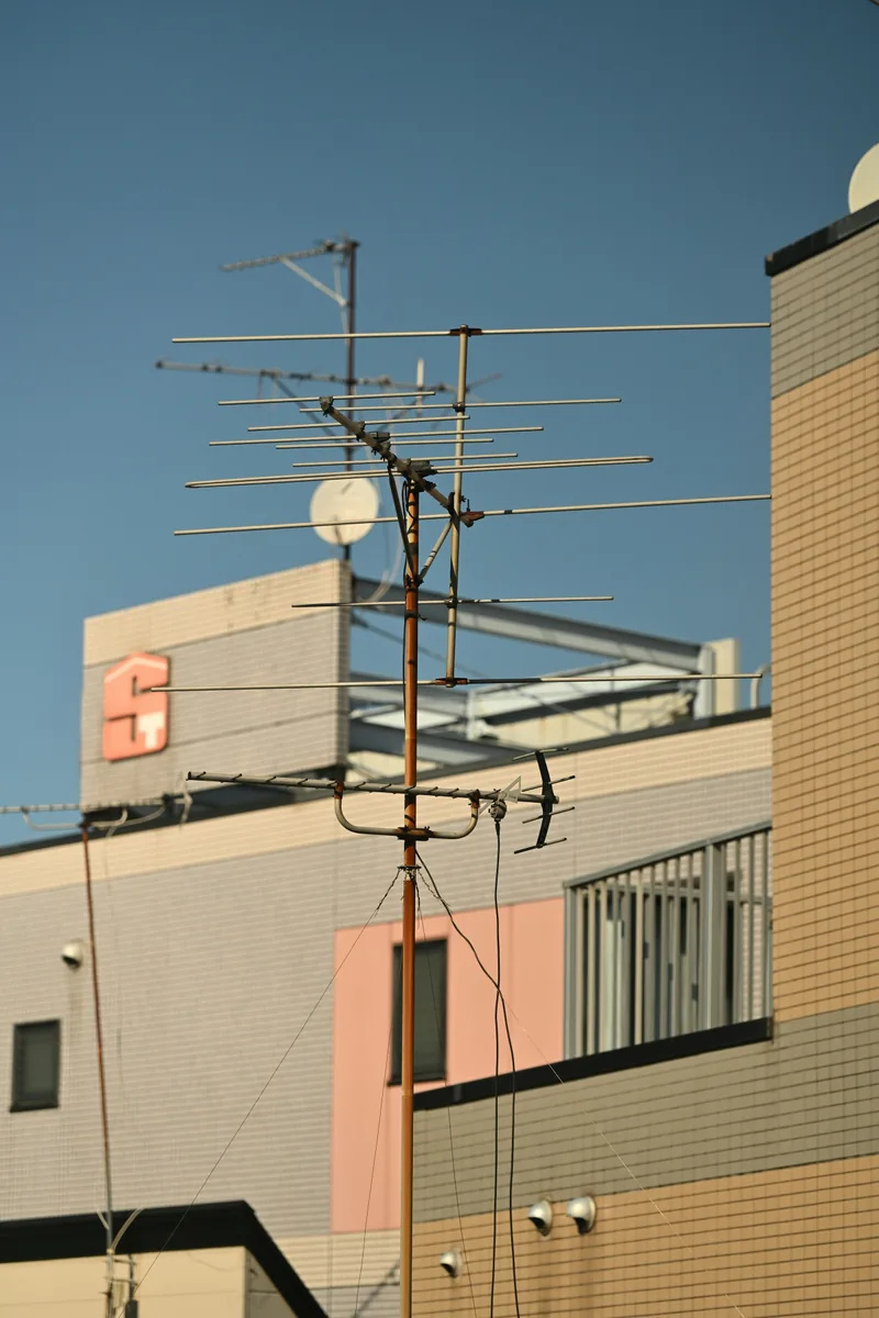 Antenna on a building against a clear blue sky
