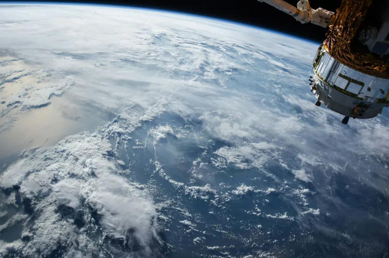 Earth seen from orbit, with part of a spacecraft in the top right corner